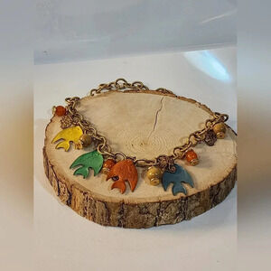 Gold-toned chain link necklace with five fish charms in various colors